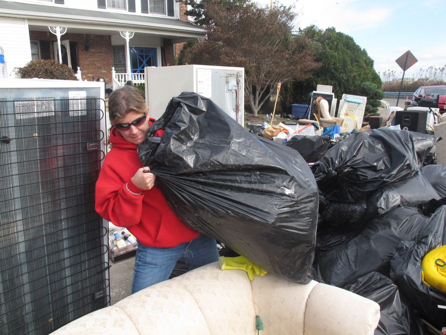 Laura DiPasquale sorts through bags of possessions that volunteers removed from her home in Point Pleasant Beach, N.J., on Monday, Nov. 5, 2012. (AP Photo/Wayne Parry)
