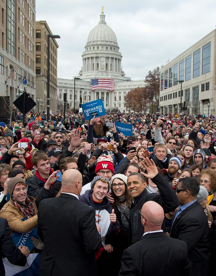 With the Wisconsin Capitol dome as a backdrop, President Obama waves to the press as he greets supporters at a campaign event on Monday, Nov. 5, 2012, in downtown Madison, Wis. (AP Photo/Carolyn Kaster)