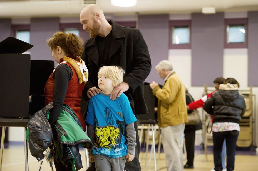 Rob Weaver and his son Ben Magnvs, 7, waits for Jessica Weaver as she finishes voting at Linwood Holton Elementary School on election day morning, Richmond, Va., Tuesday, November 6, 2012. (Andrew Harnik/The Washington Times)