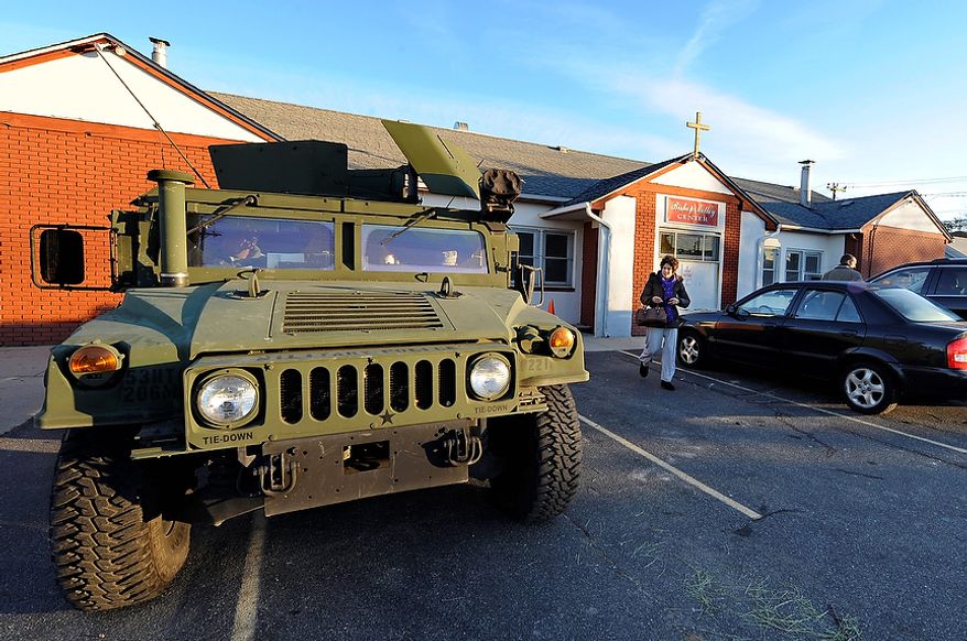 Two National Guard members stand by in their truck at Bishop Molloy Recreational Center, where voting took place on Tuesday, Nov. 6, 2012, in Point Lookout, N.Y., one of several voting locations that were created as a result of superstorm Sandy. Election Day turnout was heavy in several storm-ravaged areas in New York and New Jersey, with many voters expressing relief and even elation at being able to vote at all, considering the devastation. (AP Photo/Kathy Kmonicek)