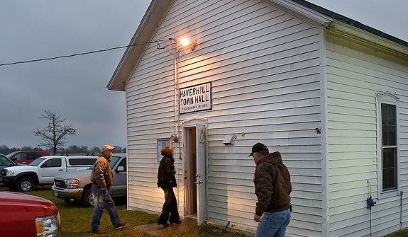 Early morning voters were not deterred by the cold rain Tuesday, Nov. 6, 2012, as they come to cast their ballots at Haverhill Town Hall, northeast of Rochester, Minn. Americans are heading to polling places across the country Tuesday. (AP Photo/The Rochester Post-Bulletin, Jerry Olson)