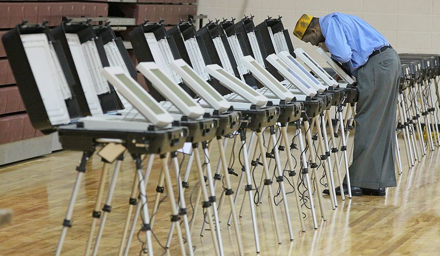 Poll Manager, Melvin Davis Jr. unlocks the voting machines at Grady High School, Tuesday, Nov. 6, 2012 in Atlanta. (AP Photo/Atlanta Journal-Constitution, John Spink)