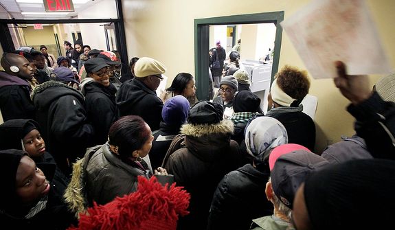 A man tries to hand his ballot, top right, to an election worker, standing in the doorway, as voters crowd an apartment building hallway, Tuesday, Nov. 6, 2012 in the Coney Island section of New York. Voting in the U.S. presidential election was the latest challenge for the hundreds of thousands of people in the New York-New Jersey area still affected by Superstorm Sandy, as they struggled to get to non-damaged polling places to cast their ballots in one of the tightest elections in recent history. AP Photo/Mark Lennihan)