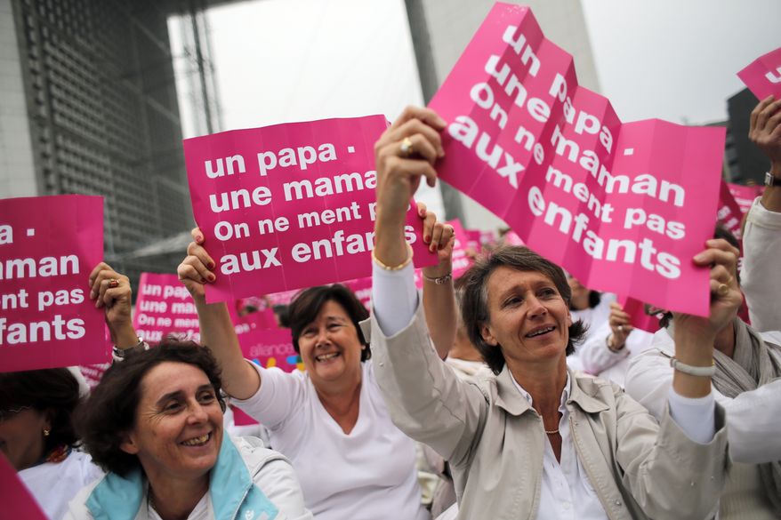 **FILE** Anti-gay marriage and gay adoption rights activists hold posters reading "Mother - Father. Don't lie to your children," while demonstrating Oct. 23, 2012, in Paris. (Associated Press)