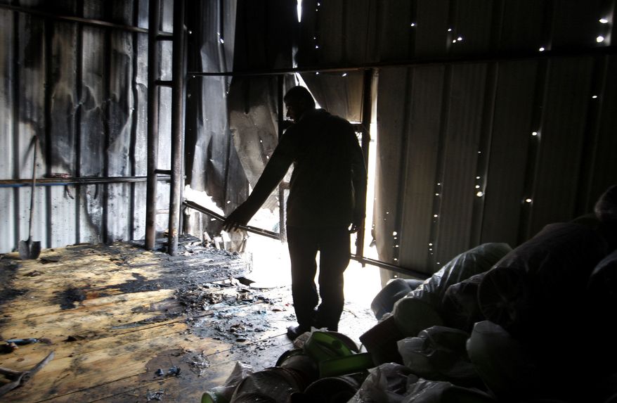 A Palestinian stands in a factory hit by an Israeli tank shell in Beit Hanoun, northern Gaza Strip, on Nov. 11, 2012. (Associated Press)