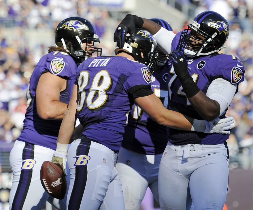 Baltimore Ravens tight end Dennis Pitta, center, celebrates his touchdown with teammates in the first half of an NFL football game against the Oakland Raiders in Baltimore, Sunday, Nov. 11, 2012. (AP Photo/Nick Wass)
