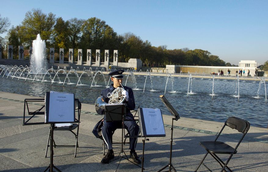 US Air Force Band Master Sargent Brett Miller warms up prior to the Veterans Day at the National World War II Memorial event. (Rod Lamkey Jr./The Washington Times)