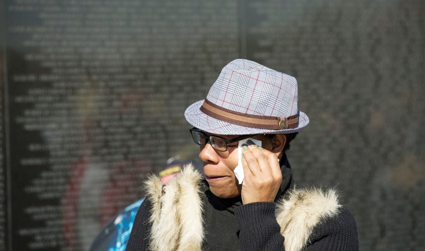 Valencia Adams, of Bowie, Md., wipes tears from her eyes after getting a pencil rubbing of the name of her father Army Pvt. Phillip C. Adams who was killed in Vietnam on May 5, 1970 after being in country for 6 months, as she visits the wall at the Vietnam Veterans Memorial during Veteran's Day weekend in Washington, D.C. Her son is retiring soon from the military after tours in Afghanistan and Iraq. (Rod Lamkey Jr./The Washington Times)