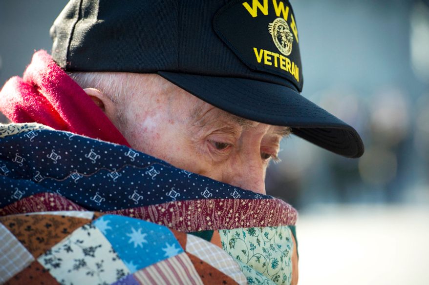 US Navy Petty Officer 3rd Class and Seabee (retired) Leon Clifton of Mt. Zion, Ill., is bundled up against the morning chill as he attends the Veterans Day at the National World War II Memorial event . (Rod Lamkey Jr./The Washington Times)