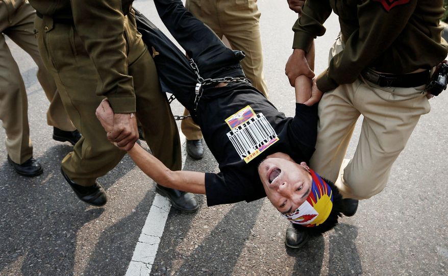 Indian police detain a Tibetan Youth Congress supporter protesting outside the Chinese Embassy in New Delhi on Monday. China has blamed the Dalai Lama for the glorification of a wave of self-immolations among Tibetans. (Associated Press)