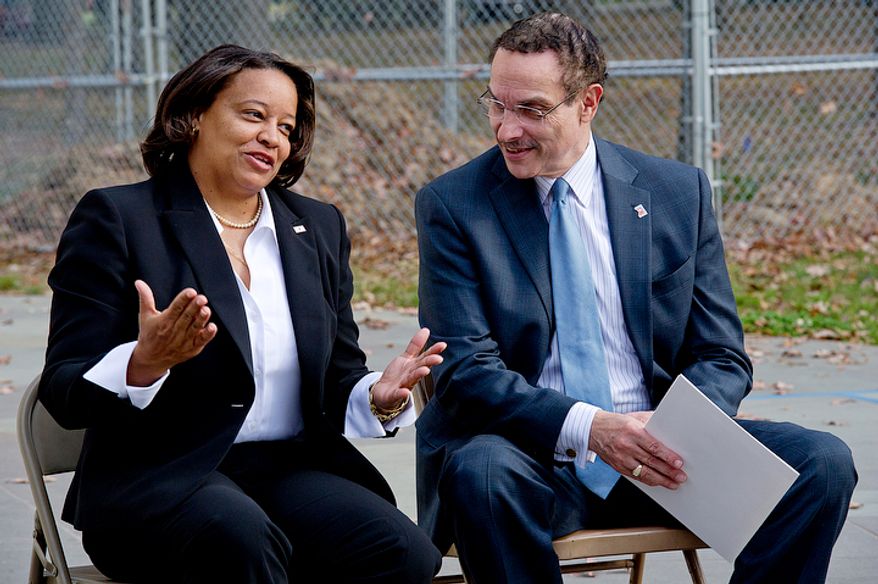 Tomi Rucker, a Washington, D.C. Navy mom, talks with Mayor Vincent Gray at the D.C. World War I Memorial on Monday, Nov. 12, 2012 about the inconsistent flying of the D.C. flag at military graduations. Ms. Rucker says she was "saddened" when the D.C. flag was not a part of her son's boot camp graduation, particularly because the flags of the other recruits' states were part of the ceremony. (Barbara L. Salisbury/The Washington Times)