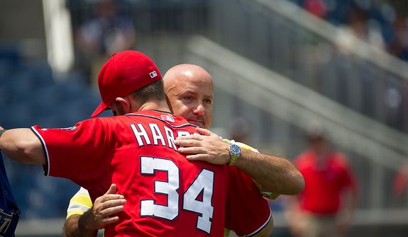 Nationals General Manager Executive Vice President of Baseball Operations Mike Rizzo gives a hug to Bryce Harper (34) prior to the game as the Washington Nationals host the Colorado Rockies at Nationals Park in Washington, D.C., Sunday, July 8, 2012. (Rod Lamkey Jr./The Washington Times)