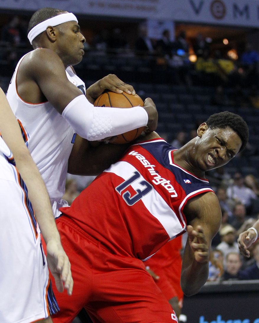 Charlotte Bobcats' Brendan Haywood, left, wrestles the ball from Washington Wizards' Kevin Seraphin, right, during the second half of an NBA basketball game in Charlotte, N.C., Tuesday, Nov. 13, 2012. Charlotte won 92-76. (AP Photo/Chuck Burton)