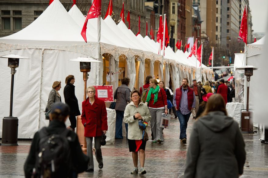 Shoppers make their way through the rain at the annual Downtown Holiday Market in front of the Portrait Gallery in Chinatown which is open until December 23rd, Washington, DC, Wednesday, December 21, 2011. (Andrew Harnik / The Washington Times)