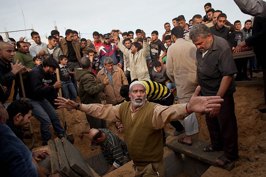 Palestinians prepare to bury the bodies of Tahrer Salman and Mohammed Salman in Beit Lahia, north Gaza, Friday, Nov. 16, 2012. According to relatives, the two members of the Salman family were killed after an Israeli airstrike hit the yard of their house. At least 22 Palestinians, including 12 militants and six children, as well as three Israelis have been killed in three days of fierce exchanges between the Israeli military and Gaza militants. (AP Photo/Bernat Armangue)
