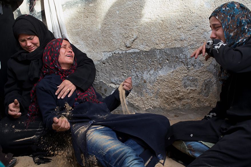 Palestinian women cry during the funeral of Tahrer Salman and Mohammed Salman in Beit Lahia, north Gaza, Friday, Nov. 16, 2012. According to relatives, the two members of the Salman family were killed after an Israeli airstrike hit the yard of their house. At least 22 Palestinians, including 12 militants and six children, as well as three Israelis have been killed in three days of fierce exchanges between the Israeli military and Gaza militants. (AP Photo/Bernat Armangue)