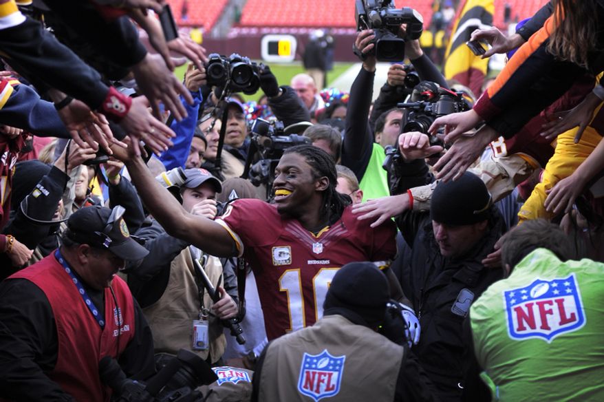 Washington Redskins quarterback Robert Griffin III (10) leaves the field surrounded fans and media after defeating the Eagles 31-6 at FedEx Field, Landover, Md., Nov. 18, 2012. (Preston Keres/Special to The Washington Times)