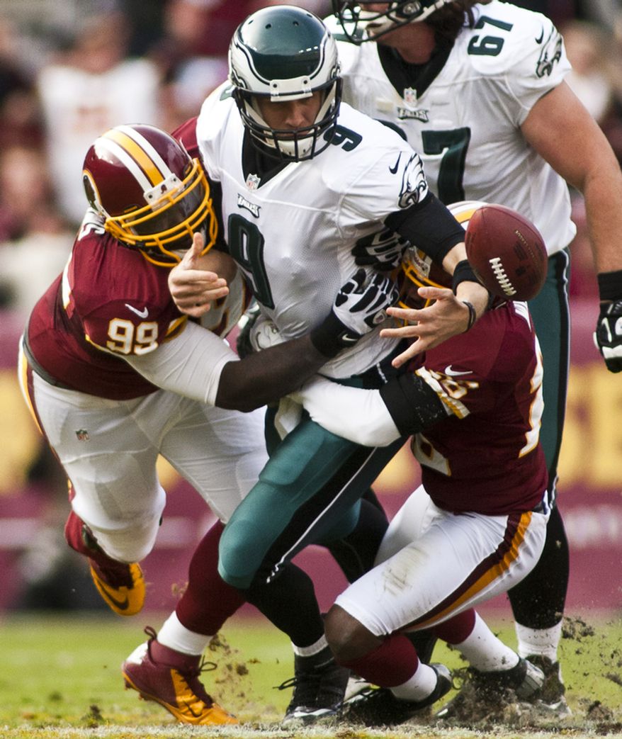 Washington Redskins defensive end Jarvis Jenkins (99) and cornerback Josh Wilson (26) force a fumble on Philadelphia Eagles quarterback Nick Foles (9) in the second half, Landover, Md., Sunday, November 18, 2012. (Craig Bisacre/The Washington Times)