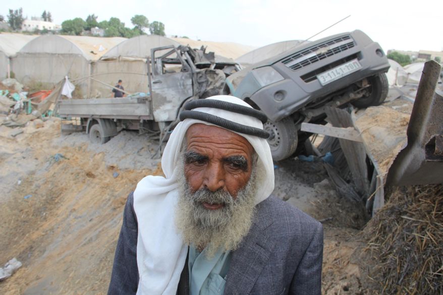 A Palestinian inspects damaged cars following an Israeli air strike in Rafah southern Gaza Strip, Monday, Nov. 19, 2012. (AP Photo/Hatem Omar)