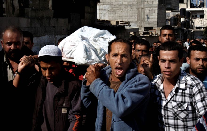 Palestinian mourners carry the body of farmer Rashed Abu Amra, 45, during his funeral in Deir Al Balah, central Gaza Strip, Monday, Nov. 19, 2012. The Palestinian civilian death toll mounted Monday as Israeli aircraft struck densely populated areas in the Gaza Strip in its campaign to quell militant rocket fire menacing nearly half of Israel's population. (AP Photo/Adel Hana)