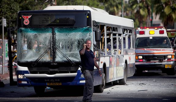 An Israeli security officer stands next to a blown up bus at the site of a bombing in Tel Aviv, Israel, Wednesday, Nov. 21, 2012. A bomb ripped through an Israeli bus near the nation's military headquarters in Tel Aviv on Wednesday, wounding several people, Israeli officials said. The blast came amid a weeklong Israeli offensive against Palestinian militants in Gaza. (AP Photo/Oded Balilty)