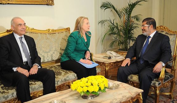 In this photo released by the Egyptian Presidency, U.S. Secretary of State Hillary Rodham Clinton, center, meets with Egyptian President Mohammed Morsi, right, and Egyptian Foreign Minister Mohammed Kamel Amr, left, in Cairo, Egypt, Wednesday, Nov. 21, 2012. Secretary of State Hillary Rodham Clinton has arrived in Cairo in her diplomatic push to forge a truce between Israel and Gaza rulers of Hamas. Her visit comes hours after a bomb exploded on an Israeli bus in Tel Aviv, wounding several. Clinton is looking to piece together a deal to end Israel's weeklong offensive in the Gaza Strip. Clinton said the U.S. "strongly condemns" today's bus bombing, calling it a "terrorist attack." (AP Photo/Egyptian Presidency)