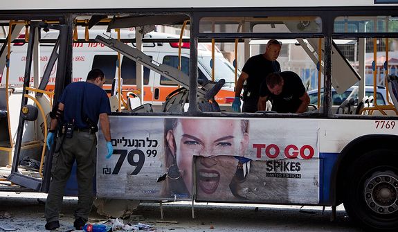 Israeli police officers examine a blown up bus at the site of a bombing in Tel Aviv, Israel, Wednesday, Nov. 21, 2012. A bomb ripped through an Israeli bus near the nation's military headquarters in Tel Aviv on Wednesday, wounding at several people, Israeli officials said. The blast came amid a weeklong Israeli offensive against Palestinian militants in Gaza. (AP Photo/Oded Balilty)