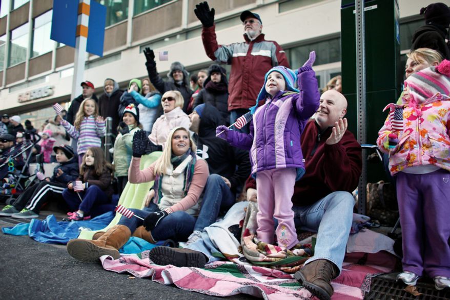 Spectators wave as they watch the 93rd annual Thanksgiving day parade, Thursday Nov. 22, 2012, in Philadelphia. New York, Chicago, and Detroit are also among the cities hosting holiday parades. (AP Photo/ Joseph Kaczmarek)