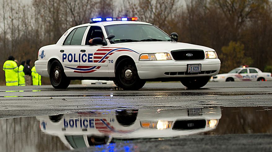 ** FILE ** Metropolitan Police officers train new recruits in safe driving techniques on a rainy day in the RFK Stadium parking lot in Washington on Tuesday, Nov. 27, 2012. (Andrew Harnik/The Washington Times)