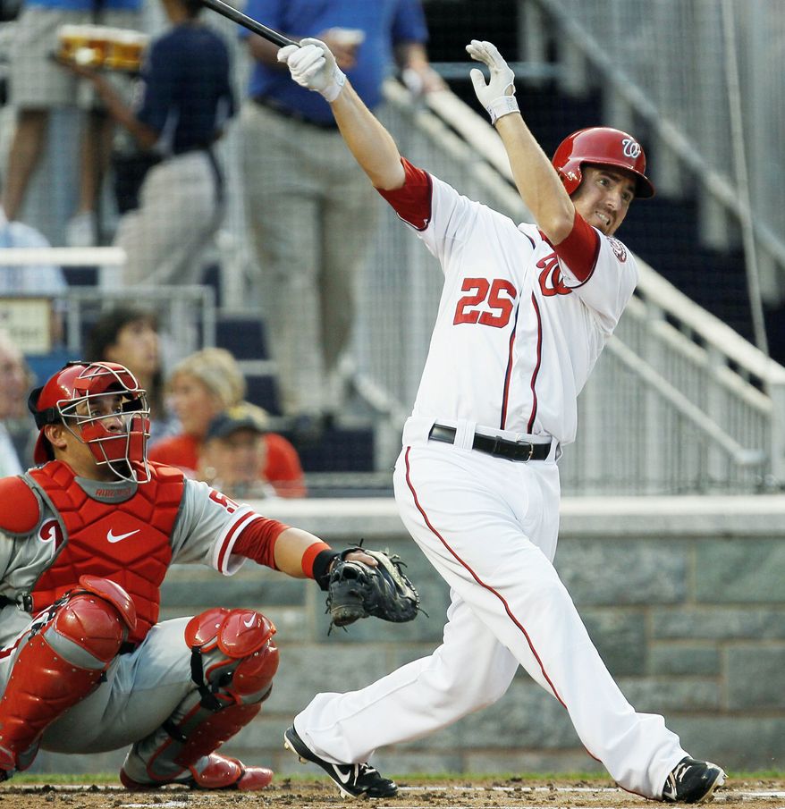 Washington Nationals' Adam LaRoche follows through on a home run as Philadelphia Phillies catcher Carlos Ruiz (51) watches during the second inning of a baseball game, Thursday, Aug. 2, 2012, in Washington. (AP Photo/Carolyn Kaster)