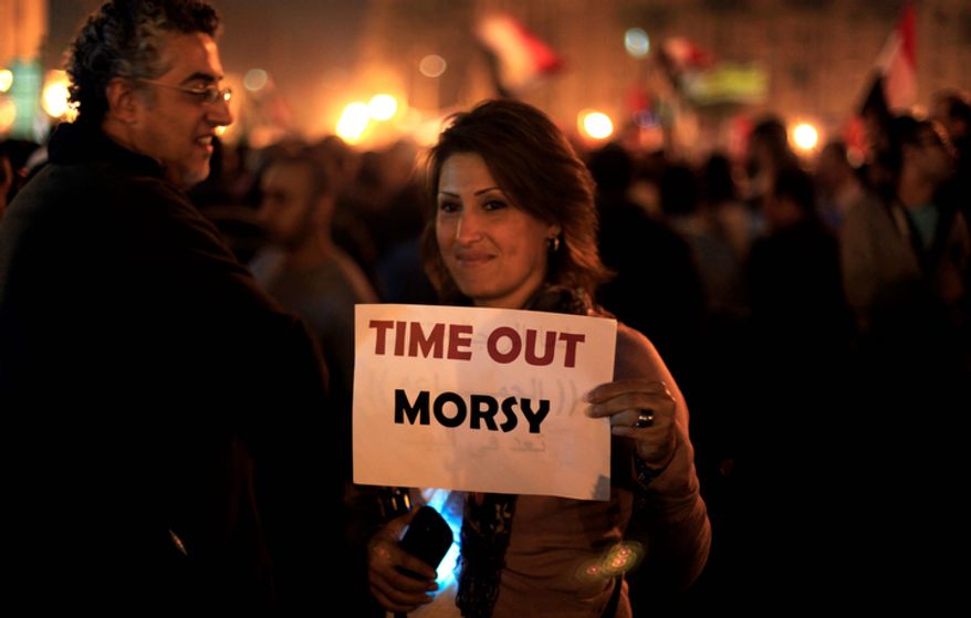 A protester holds a placard against the Egyptian president at an opposition rally in Tahrir Square in Cairo on Tuesday, Nov. 27, 2012. (AP Photo/Khalil Hamra)