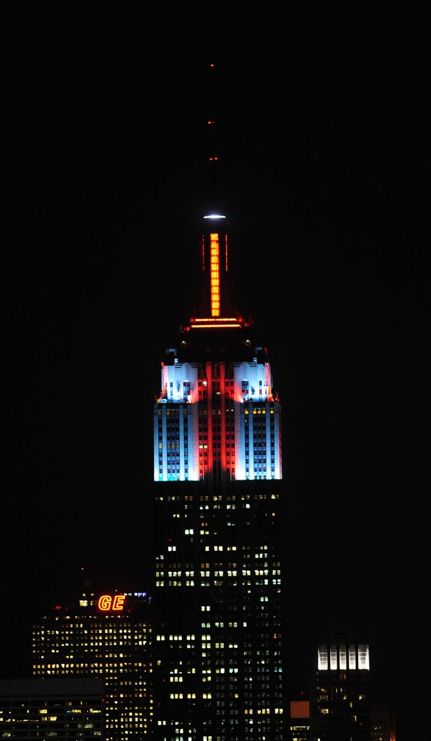 The top floors of New York's Empire State Building are lit in gold, red, blue and white light on Monday, Nov. 26, 2012, after a new LED illumination system was switched on by R&B star Alicia Keys. (AP Photo/Empire State Building, Bryan Smith)