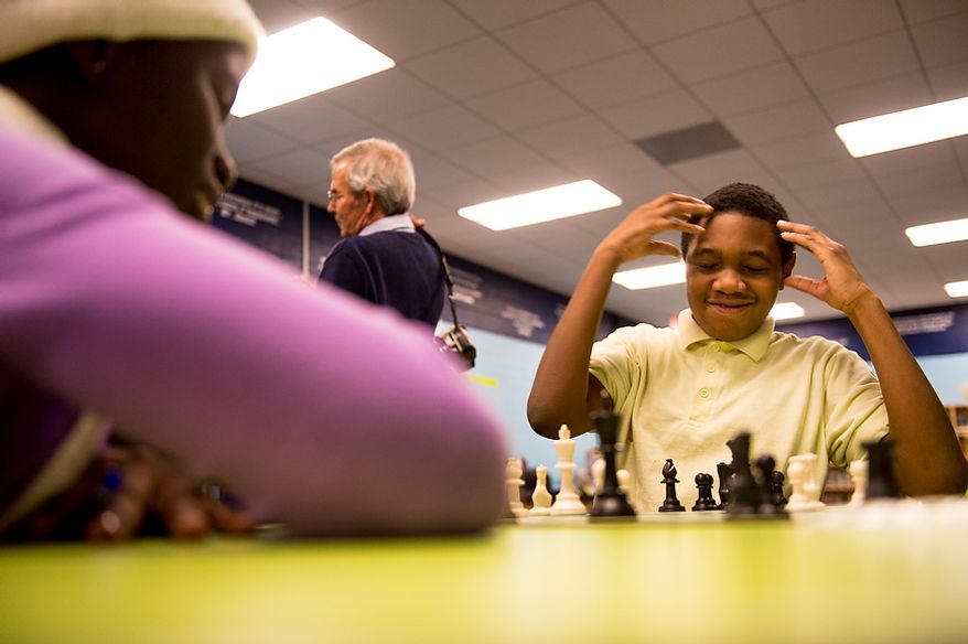 Hart Middle School student Timothy Joyner, 11, right, reacts as he struggles to play Phiona Mutesi, 15, a national chess champion from Uganda, left, as Mutesi visits with District elementary and middle school students in the after school group Chess Challenge in D.C. at Hart Middle School in Southeast, Washington, D.C., Tuesday, November 27, 2012. Chess Challenge in D.C. is a non-profit that teaches the game of chess as well as life skills to students in 24 schools in the District. Mutesi, who is now a international chess player who is also on a book tour, was discovered by Sports Outreach Institute, an evangelical organization that feeds, educates and teaches sports. (Andrew Harnik/The Washington Times)