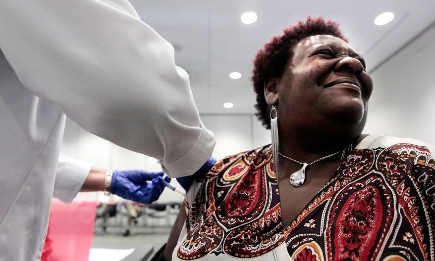 **FILE** Elizabeth Saint Victor winces as she gets a free flu shot from nurse Jean Buck courtesy of Baptist Healthcare at the Central Library in Memphis, Tenn., on Oct. 30, 2012. (Associated Press/The Commercial Appeal)