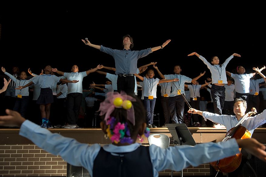 Damian Woetzel, center, a former principal dancer with the New York City Ballet, leads a group of Savoy Elementary School students, both on stage and in the audience, in a dance during a performance at the Southeast Washington, D.C. school on Tuesday, Dec. 4, 2012. Mr. Woetzel and world renowned cellist Yo Yo Ma came to the school to work with students in a small private workshop and then perform for the entire school. (Barbara L. Salisbury/The Washington Times)