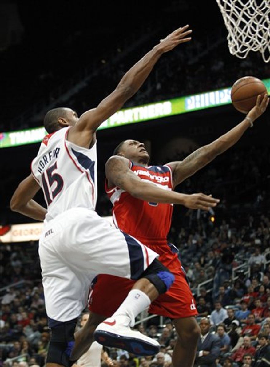 Washington Wizards guard Bradley Beal is fouled as he drives to the basket by Atlanta Hawks center Al Horford (15) in the second half of an NBA basketball game Friday, Dec. 7, 2012, in Atlanta. Atlanta won 104-95. (AP Photo/John Bazemore)
