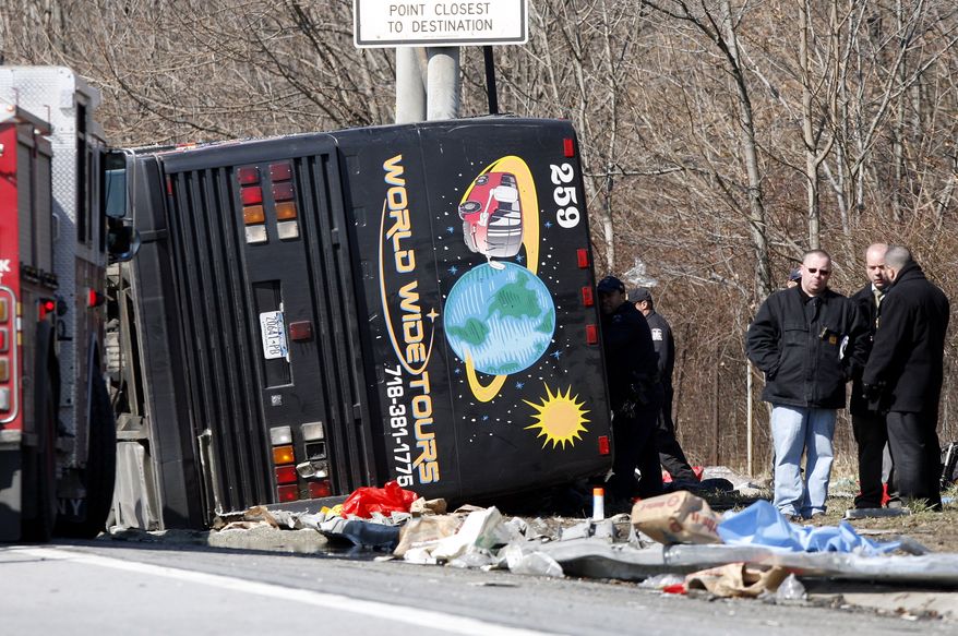 **FILE** Emergency personnel investigate the scene of a bus crash on Interstate 95 in the Bronx borough of New York on March 12, 2011. The bus driver, Ophadell Williams, who was charged in the crash that killed 15 passengers, said a tractor-trailer cut him off and he lost control. The bus carrying gamblers coming from a Connecticut casino was sheared open like a sardine can when it struck a pole. (Associated Press)