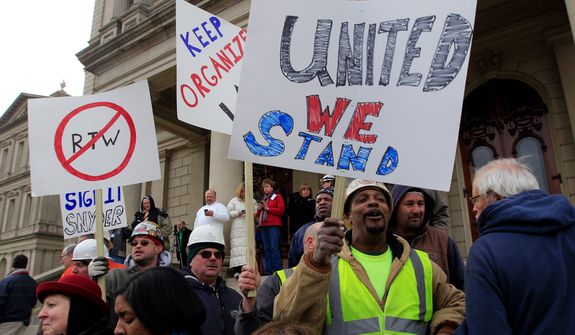 Union workers rally outside the Capitol in Lansing, Mich., Thursday, Dec. 6, 2012 as Senate Republicans introduced right-to-work legislation in the waning days of the legislative session. The outnumbered Democrats pledged to resist the proposal and said rushing it through the legislative system would poison the state's political atmosphere. (AP Photo/Carlos Osorio)
