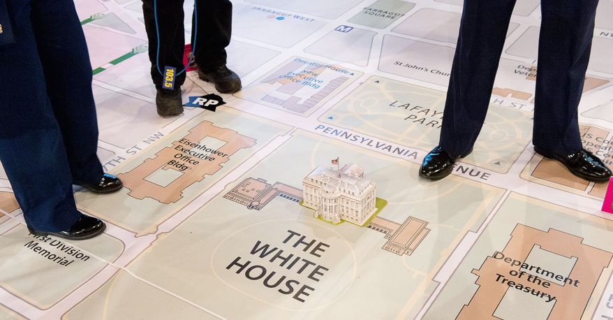 Members of the media crowd around a model of the White House as the Joint Task Force - National Capital Region and the D.C. National Guard hold a final inauguration day planning symposium using a 40- by 60-foot map of downtown D.C. and the National Mall, Washington, D.C., Wednesday, December 12, 2012. The inauguration day events are planned out for months with a number of different military and civilian organizations. (Andrew Harnik/The Washington Times)