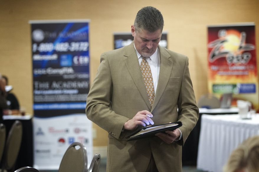 A job seeker uses his iPad to fill out job applications at the Fort Lauderdale Career Fair in Dania Beach, Fla., on Friday, Nov. 30, 2012. (AP Photo/J. Pat Carter)