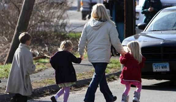 ** FILE ** Parents walk away from the Sandy Hook Elementary School with their children following a mass shooting at the school on Friday, Dec. 14, 2012, in Newtown, Conn. Twenty schoolchildren and six adults were killed. (AP Photo/The Journal News, Frank Becerra Jr.)