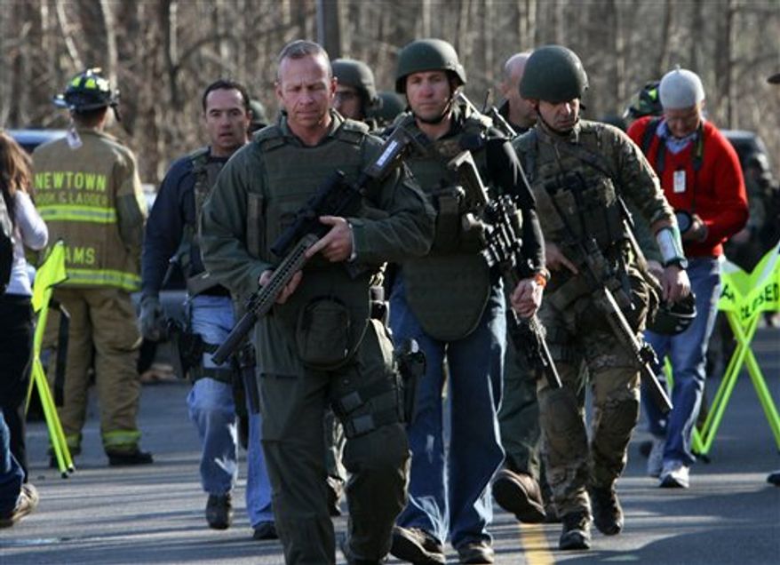 Heavily armed Connecticut State troopers are on the scene at the Sandy Hook School following a shooting at the school, Friday, Dec. 14, 2012 in Newtown, Conn. A man opened fire inside the Connecticut elementary school where his mother worked Friday, killing 26 people, including 18 children, and forcing students to cower in classrooms and then flee with the help of teachers and police. (AP Photo/The Journal News, Frank Becerra Jr.) MANDATORY CREDIT, NYC OUT, NO SALES, TV OUT, NEWSDAY OUT; MAGS OUT