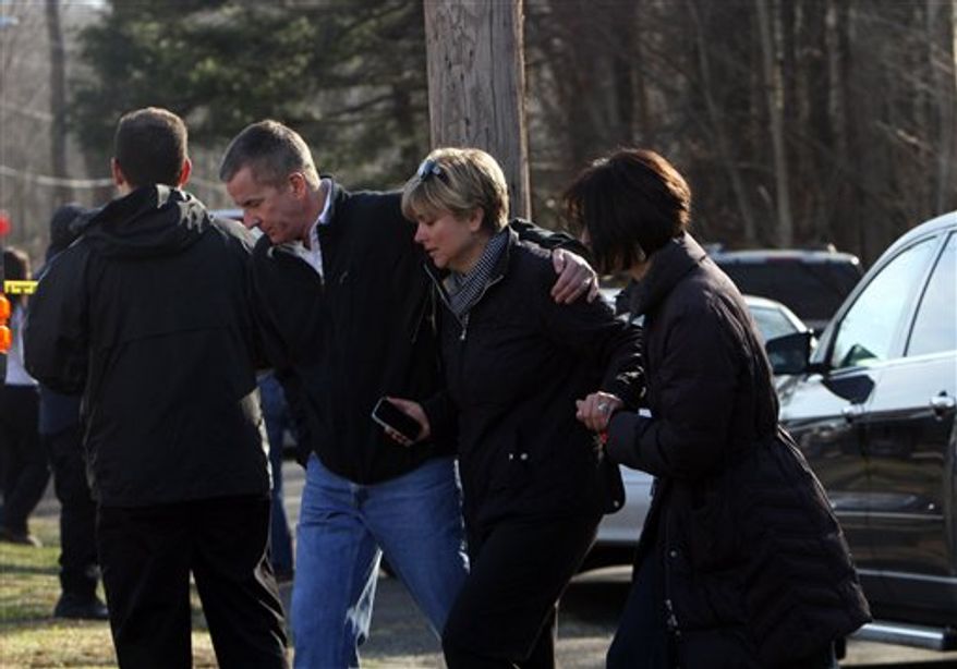 Teachers walk away from the Sandy Hook School following a shooting at the school, Friday, Dec. 14, 2012 in Newtown, Conn. A man opened fire inside the Connecticut elementary school where his mother worked Friday, killing 26 people, including 18 children, and forcing students to cower in classrooms and then flee with the help of teachers and police. (AP Photo/The Journal News, Frank Becerra Jr.) MANDATORY CREDIT, NYC OUT, NO SALES, TV OUT, NEWSDAY OUT; MAGS OUT