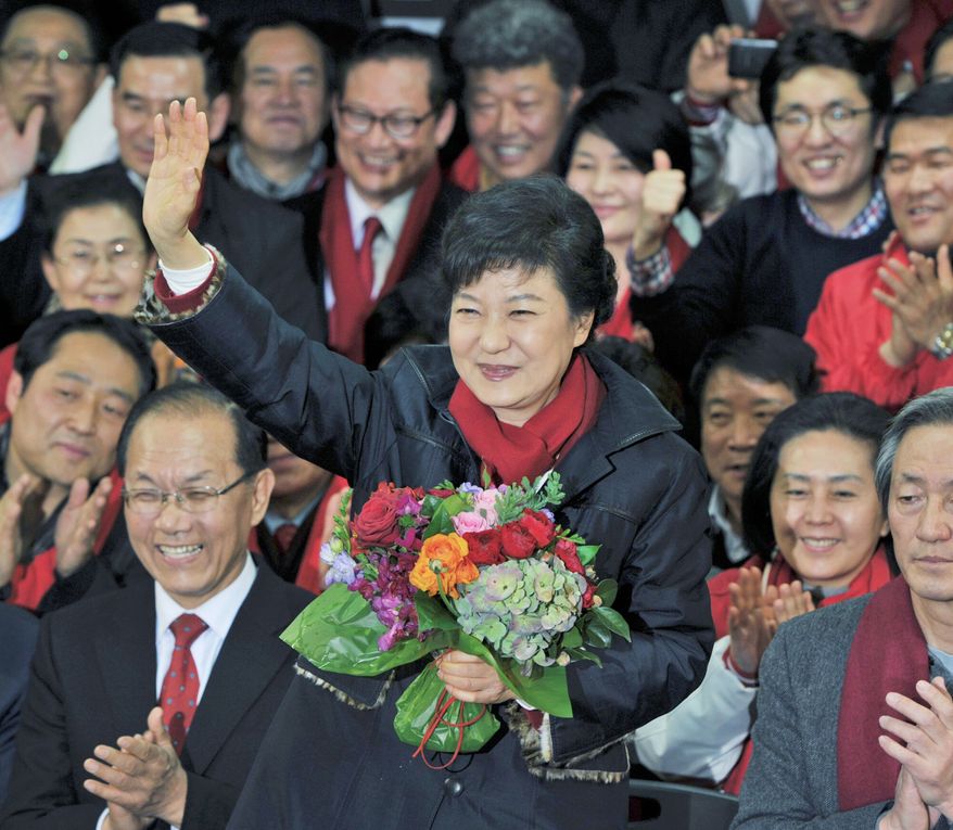 Park Geun-hye waves to supporters after arriving at the party headquarters in Seoul on Wednesday. The new South Korean president will be returning to the presidential palace where her father, Park Chung-hee, ruled for 18 years. (Associated Press)