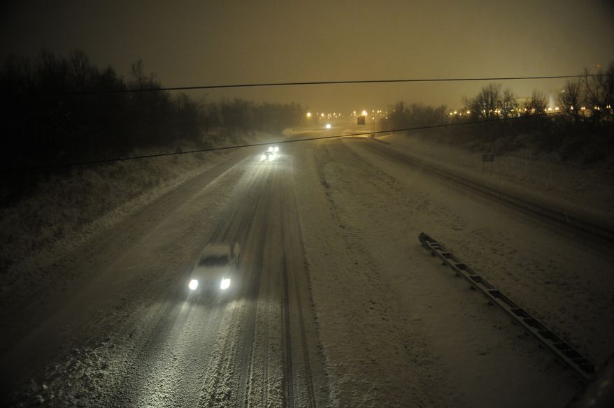 Motorists travel slowly on a snow-covered Interstate 24 in Paducah, Ky., during a winter storm on Dec. 26, 2012. The storm dumped several inches of snow, making travel hazardous. (Associated Press)