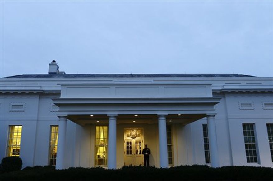 ** FILE ** A Marine sentry stands guard at the White House on Tuesday, Jan. 1, 2013, an indication that President Obama is working in the West Wing. (Associated Press)
