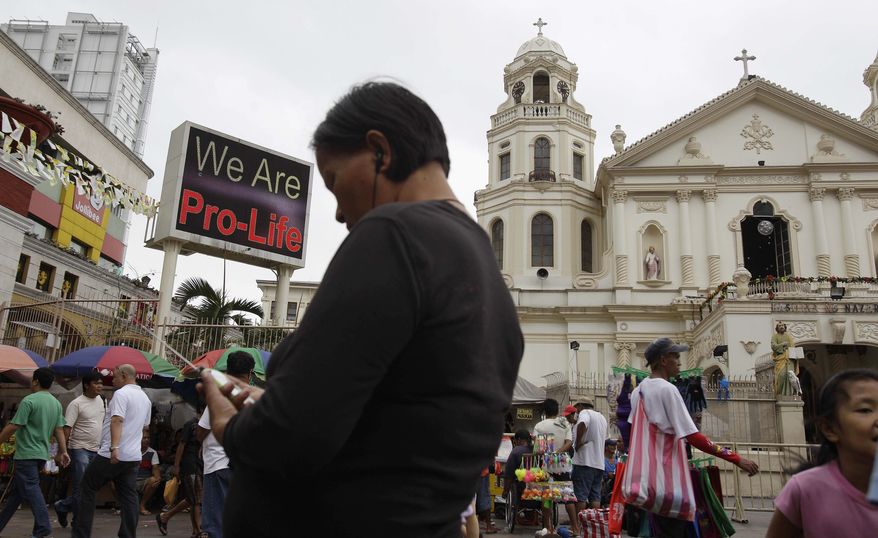 A "Pro-Life" message flashes on an electric signboard outside the Roman Catholic Minor Basilica of the Black Nazarene in downtown Manila on Thursday, Jan. 3, 2013. (AP Photo/Aaron Favila)