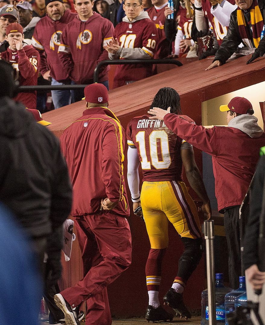 Medical staff members take Griffin into a sideline training room to look at his injured knee late in the fourth quarter Sunday. Coach Mike Shanahan said Monday the extent of the injury remains unknown. (Andrew Harnik/The Washington Times)