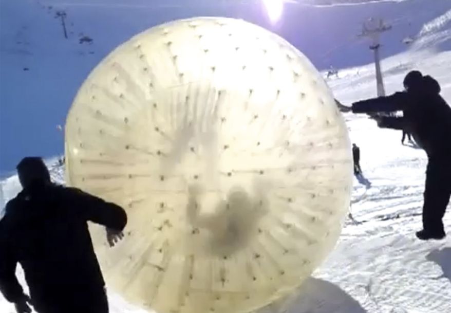 This frame grab made Wednesday Jan. 9, 2013, was taken from APTN video provided by Yekaterina Achkasova, as her husband Denis Burakov and another man are seen inside a large plastic ball called a zorb, on Thursday, Jan. 3, 2013, while other man pushed it, at a winter sports venue at Donbay in the Caucasus Mountains of southern Russia. The zorb veered off course and sailed over a cliff, killing Burakov and leaving the other man badly injured. (AP Photo/Family photo provided by Yekaterina Achkasova, APTN)