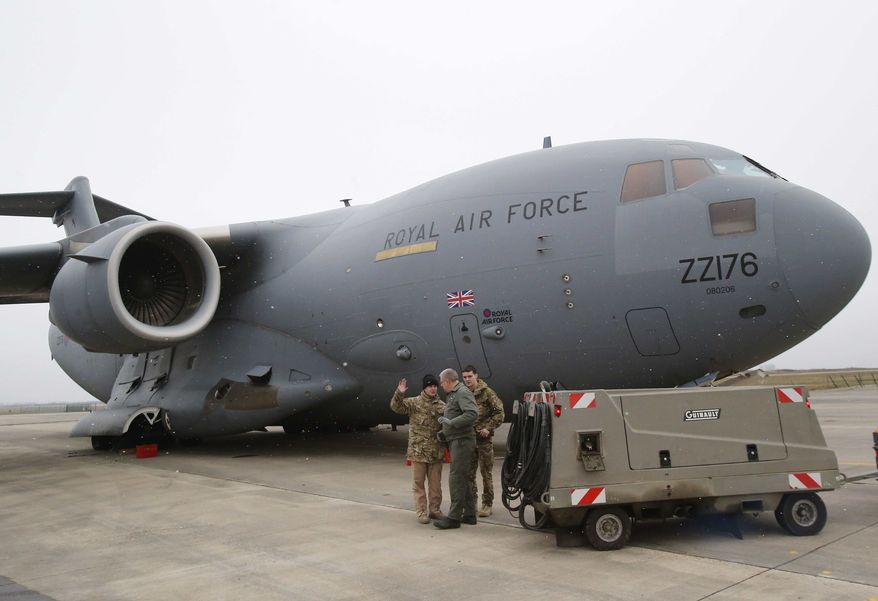 A French airman, center, talks to British military personnel prior to the take off a British C17 transport plane enroute to Mali at the French army base in Evreux, 90 kms (56 mls )north of Paris, Monday, Jan. 14, 2013. (AP Photo/Michel Euler)